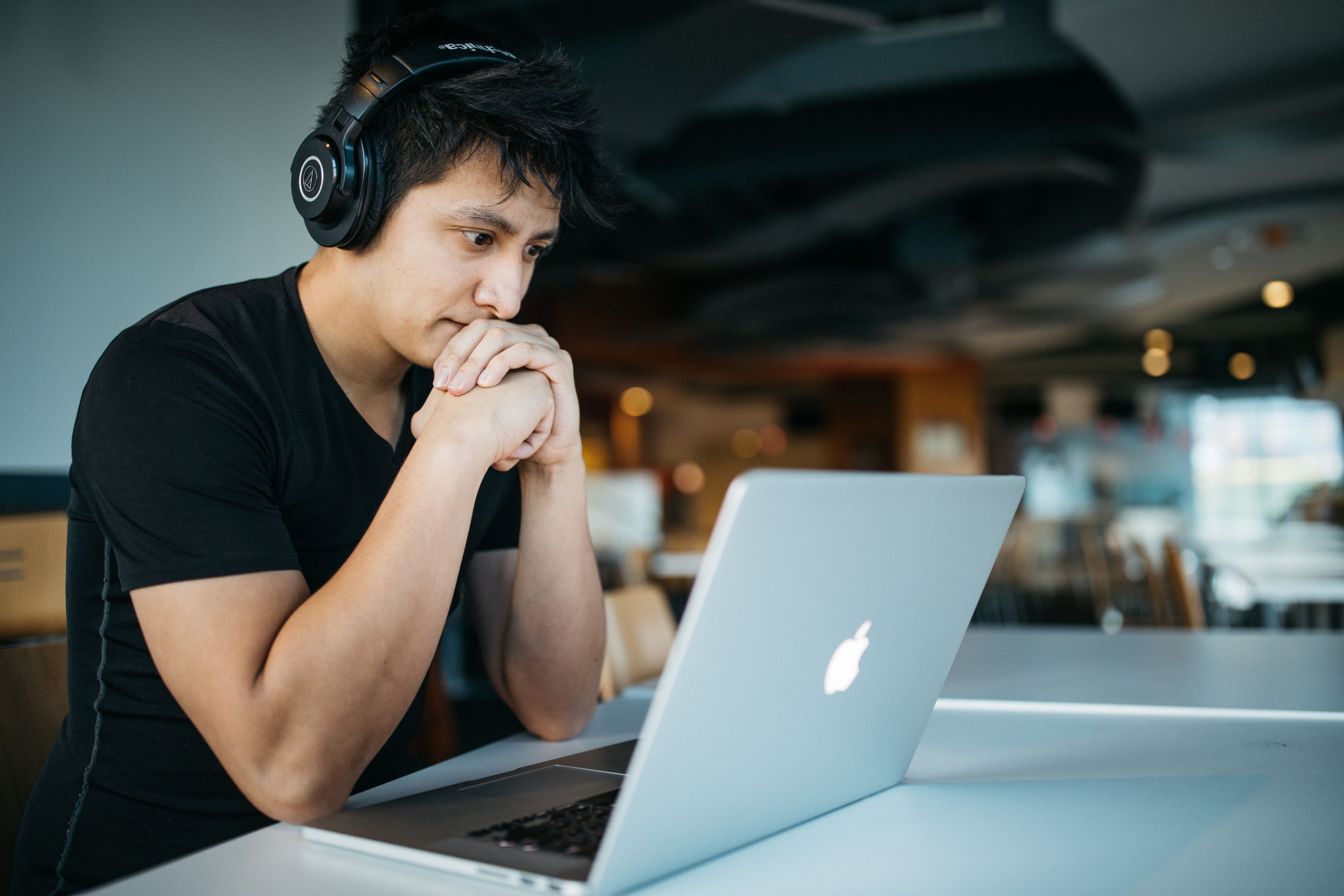 Man wearing headphones working on his laptop