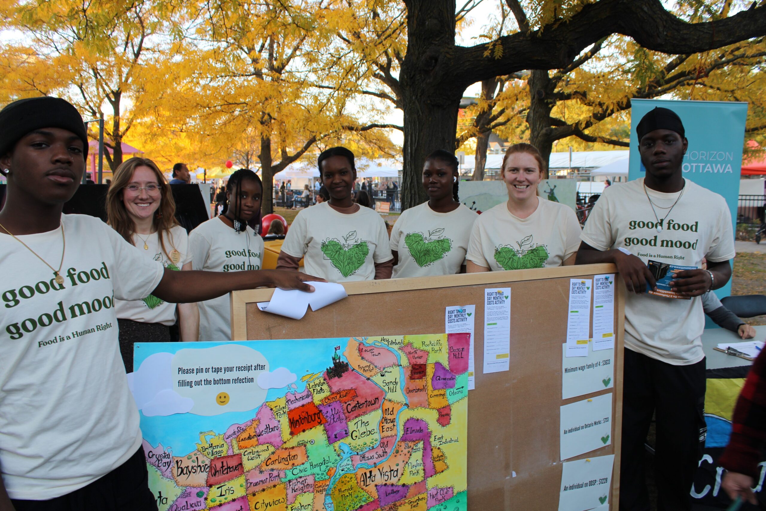 A group of youth stand around a message board.